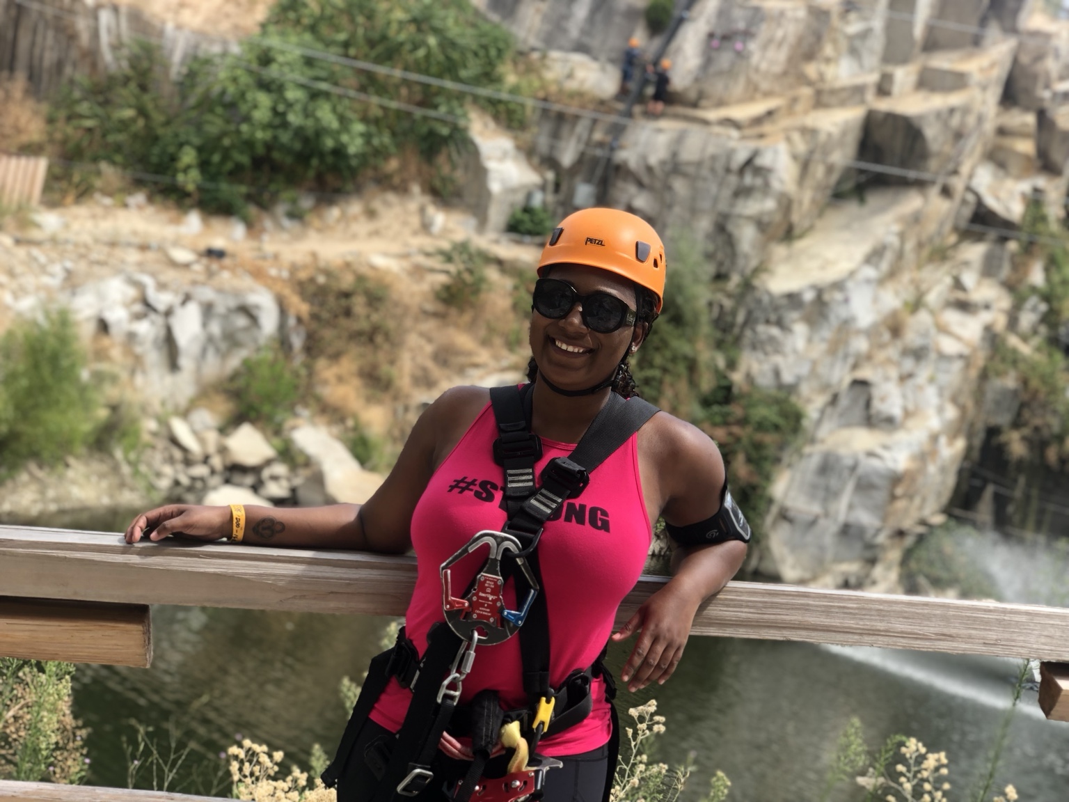 Madoree smiling in a helmet and adventure harness